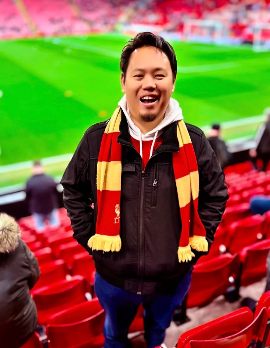 Mirza Salim, founder of Matchday Affairs, pitchside at Anfield wearing a Liverpool scarf